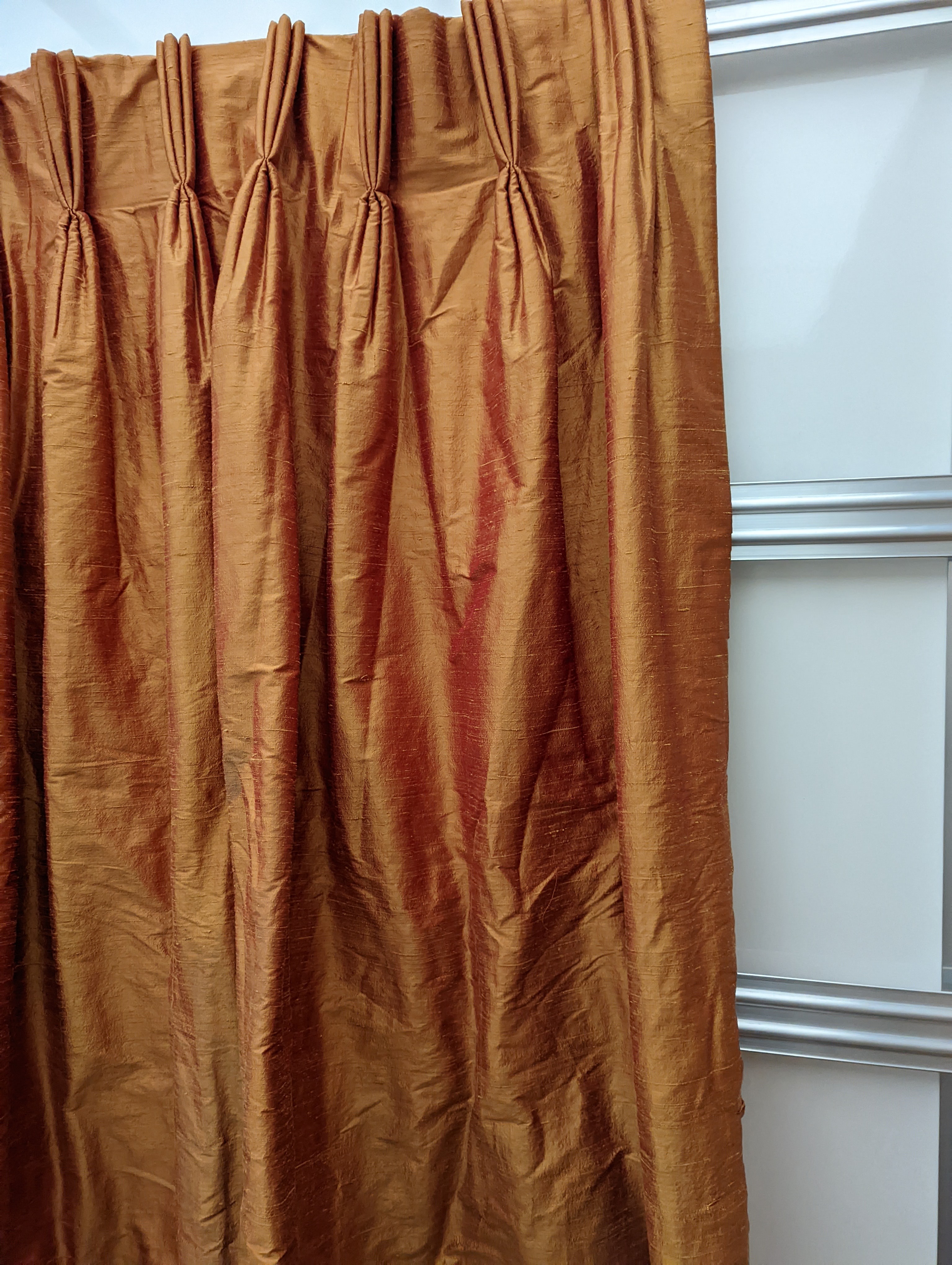 A pair of orange lined curtains. Approximate measurements: Width of top 180cm, Width of bottom 320cm Length 250cm